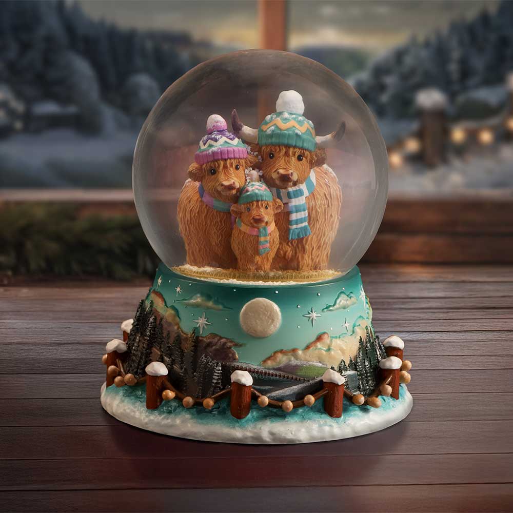Winter Highland Cow snow globe by Nemesis Now, 13.7cm tall, featuring a Highland cow inside a snowy scene.
